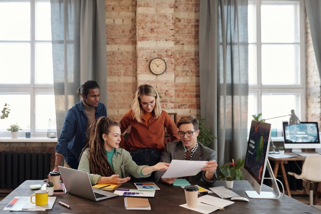 A diverse team of young professionals working on a business strategy in an urban office setting.